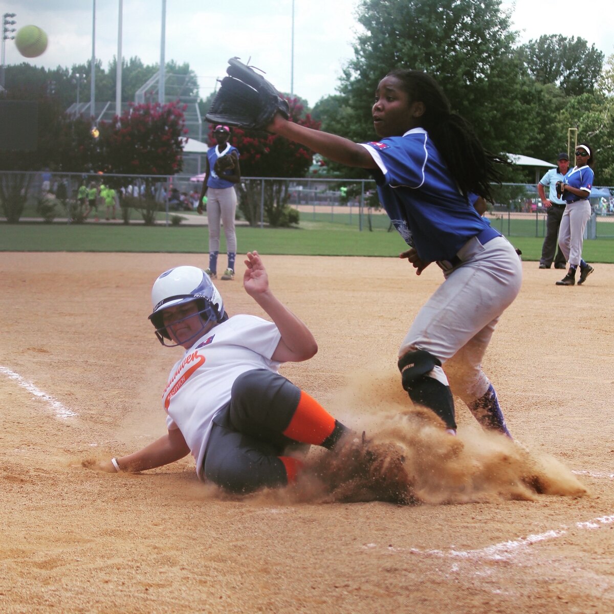 Softball player reaching to make a catch during a close play